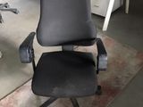 a black office chair that is sitting in the middle of a room