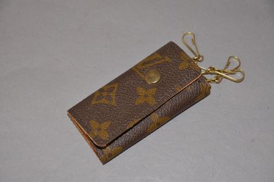 un petit portefeuille marron auquel est attaché un porte-clés