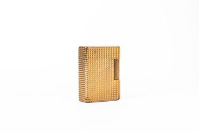 un briquet doré posé sur une surface blanche