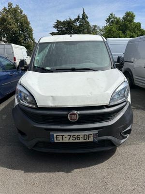 la camionnette blanche est garée dans le parking à côté d'autres voitures