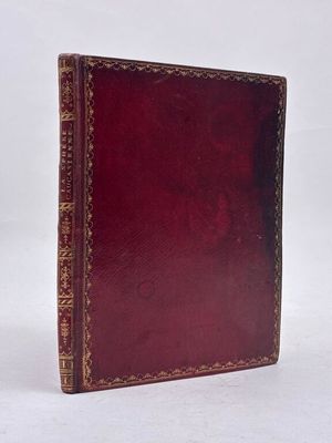 un vieux livre à la couverture rouge posé sur une surface blanche