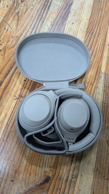 un casque audio dans son étui, posé sur un parquet