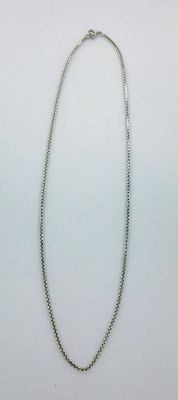 a close up of a necklace on a white surface