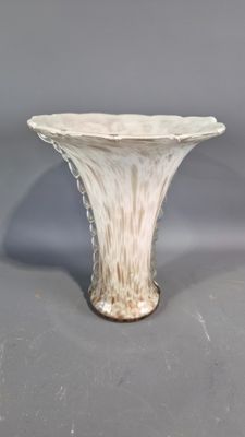 a white vase that is sitting on a table
