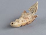 une petite tête d'animal sculptée sur une surface grise