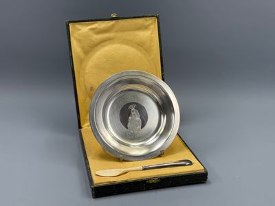 an antique silver plate with a spoon and spoon rest in a box