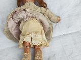 a doll that is laying down on a white sheet