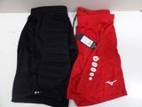 deux paires de shorts de basket rouges et noirs posés sur une surface blanche