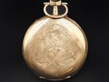an old gold pocket watch with a picture of a man on it