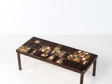 La table basse est en bois et présente un motif en mosaïque.