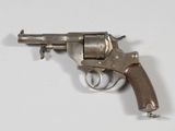 un vieux revolver avec une poignée en bois sur une surface blanche