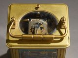 a small gold clock with a clock face on it