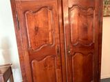 a large wooden armoire with two doors on the top of it