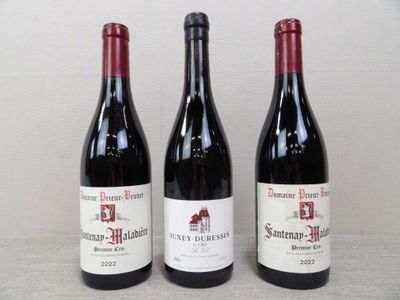 trois bouteilles de vin rouge posées sur une table l'une à côté de l'autre