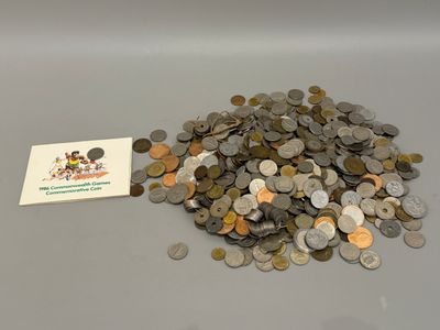 une pile de pièces posée sur une table à côté d'une carte de visite