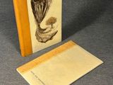 an open book with a picture of a plant on it and a piece of paper next to it