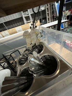 a sink with a bunch of silver spoons and utensils in it