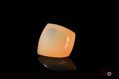 a close up of a yellow opalite stone on a black surface