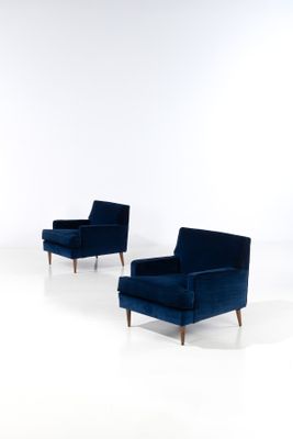 une paire de fauteuils de salon en velours bleu avec des pieds en noyer
