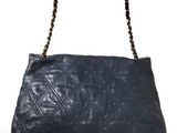 a black handbag with a chain strap and studded handles