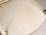 an image of a white chair with a striped seat cushion