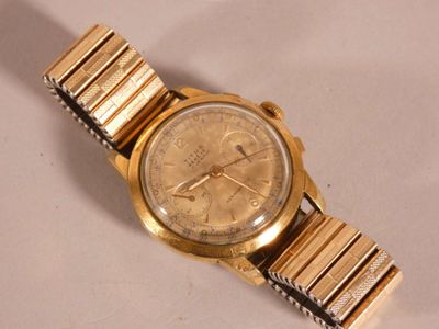 a gold wrist watch on a white surface