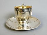 a silver cup and saucer on a saucer on a saucer