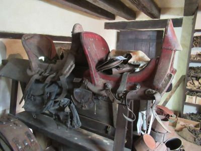 many different types of saddles on display in this room