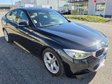 the bmw 3 series sedan is parked in front of a dealership