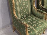 pair of green and gold painted chairs in a corner of a room