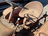 a rusted old tractor sitting on the side of the road