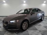 a gray audi parked on a checkered tile floor in a garage