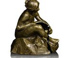 bronze statue of a woman sitting on a rock with a dog