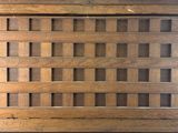 a picture of a wooden floor grate with holes in it