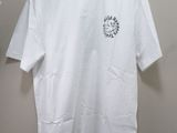 white t - shirt hanging on a hanger on a wall