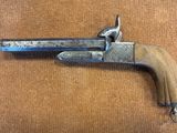 gros plan d'un pistolet avec une poignée en bois sur une surface brune