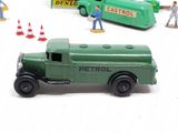 a green toy truck that is next to other toy vehicles