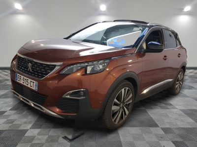 Une voiture marron est garée sur un sol à damier dans un garage.