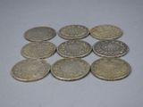 several coins are arranged on a white surface with a small amount of them