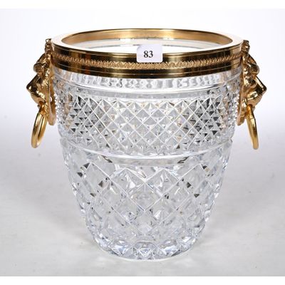 an antique cut glass ice bucket with gold trimming and handles