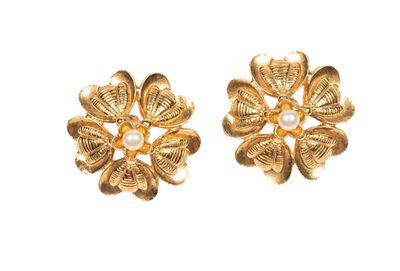 une paire de boucles d'oreilles en or ornées de perles sur fond blanc