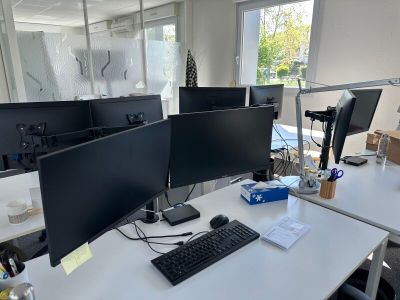 trois écrans d'ordinateur posés sur le bureau
