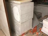 une pile de cartons, les uns sur les autres, posée par terre dans une pièce