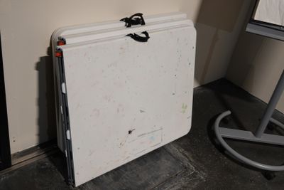 un tableau blanc posé par terre à côté d'un chevalet