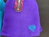 purple and blue beanies with a heart tag on them
