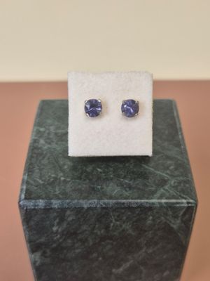 a pair of blue sapphire earrings sitting on top of a marble block