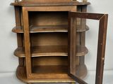 an old wooden display cabinet with a glass door open