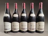 six bottles of red wine lined up in a row on a table