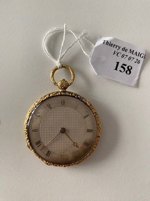 a gold pocket watch hanging on a white wall