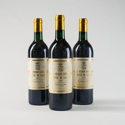trois bouteilles de vin posées les unes à côté des autres sur une surface blanche